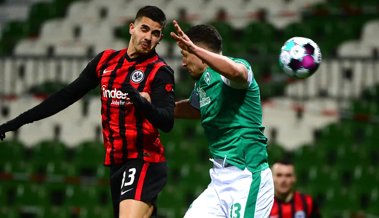 Striker Eintracht Frankfurt, Andre Silva (kiri) berduel udara dengan bek Werder Bremen, Milos Veljkovic dalam laga lanjutan Liga Jerman 2020/21 pekan ke-23 di Weserstadion, Bremen, Jumat (26/2/2021). Eintracht Frankfurt kalah 1-2 dari Werder Bremen. (AFP/Patrik Stollarz/Pool)