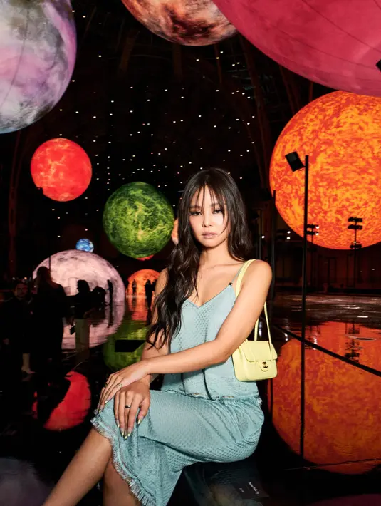 Jennie BLACKPINK tampil estetik dengan tanktop dan rok midi satin yang mirip baju tidur. Dipadu dengan Chanel Flapbag Mini kuning pastel [Chanel]