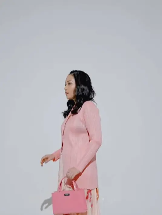 Ayla Dimitri memadukan penampilannya yang ekletik dengan tas Kate Spade. Ia menenteng tas versatile Sam Icon Small Tote berwarna Feather Pink dalam balutan jas blazer fitted berwarna pink dan rok panjang berbahan pleats. Foto: Document/Kate Spade New York.
