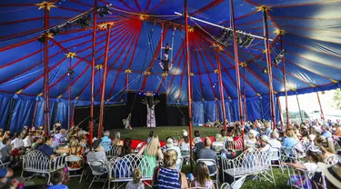 Akrobat di bawah tenda besar memukau penonton selama pertunjukan Flynn Creek Circus di Avon, Colorado (14/8/2021). Pertunjukkan ini menerapkan tempat duduk ramah Covid-19 dengan meja individu per pesta. (Chris Dillmann/Vail Daily via AP)