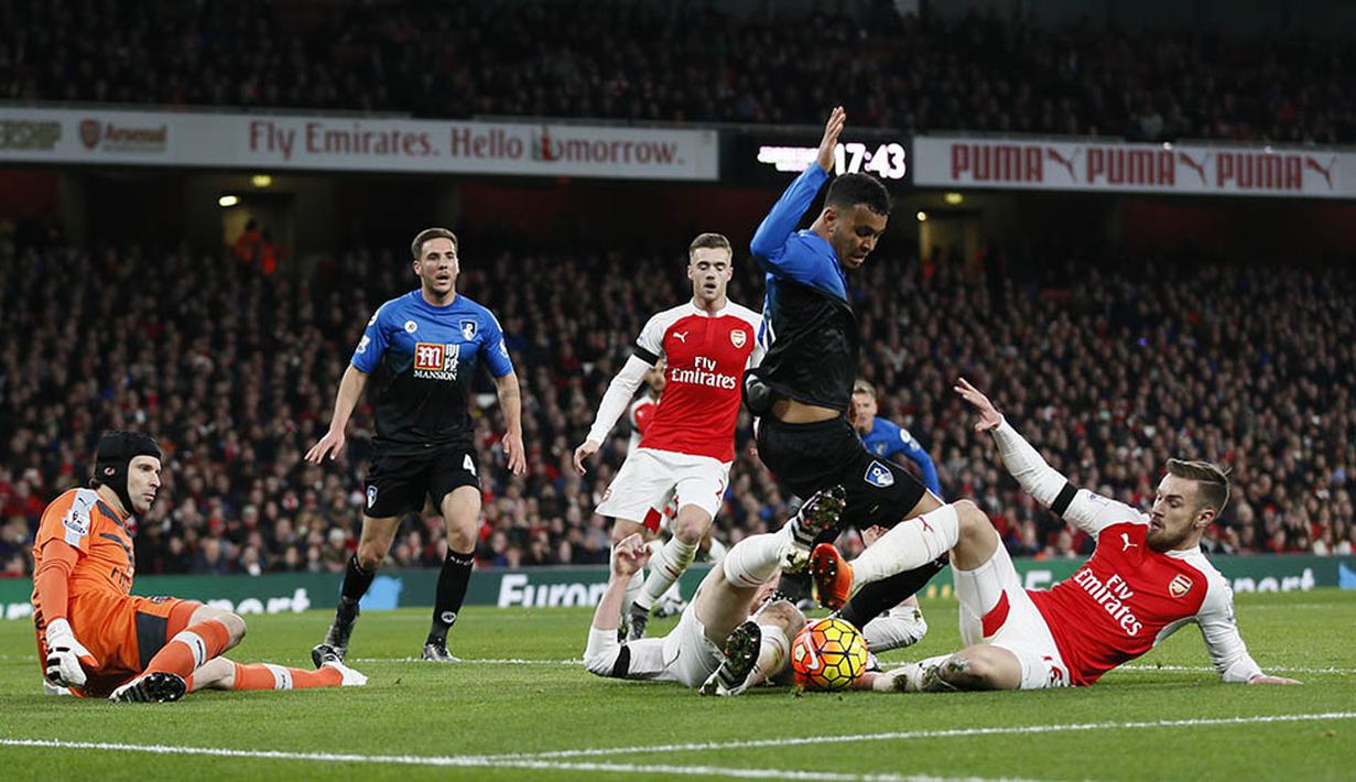 Gelandang Arsenal, Aaron Ramsey, terjatuh saat berebut bola dengan pemain Bournemouth, Joshua King, pada laga Premier League di Stadion Emirates, Inggris. (Reuters/Stefan Wermuth)