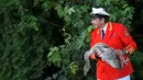 Petugas Penanda Angsa dan Pengasuh Angsa (Swan Marker) menangkap seekor angsa dalam Swan Upping di Shepperton, Inggris (18/7). Acara ini merupakan tradisi tahunan untuk menghitung jumlah angsa di Inggris. (REUTERS/Toby Melville)
