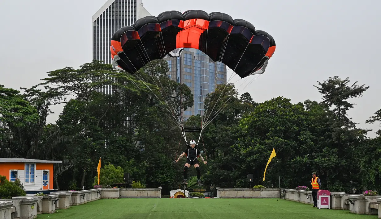 Penerjun Jerman Maxim Tepper mendarat setelah melompat dari dek terbuka Menara Kuala Lumpur saat International Tower Jump, Kuala Lumpur, Malaysia, 3 Februari 2023. Lebih dari 100 penerjun melompat dari Menara Kuala Lumpur setinggi 300 meter yang terkenal tersebut. (MOHD RASFAN/AFP)