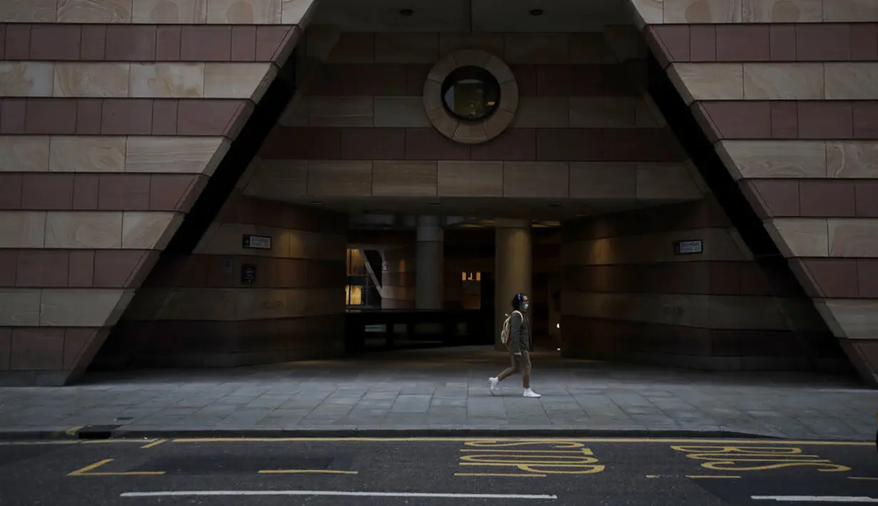 Seorang pria berjalan pada pagi pertama penerapan lockdown nasional ketiga di Kota London, Inggris, 5 Januari 2021. Penerapan lockdown nasional ketiga di Inggris berlangsung selama enam minggu. (AP Photo/Matt Dunham)