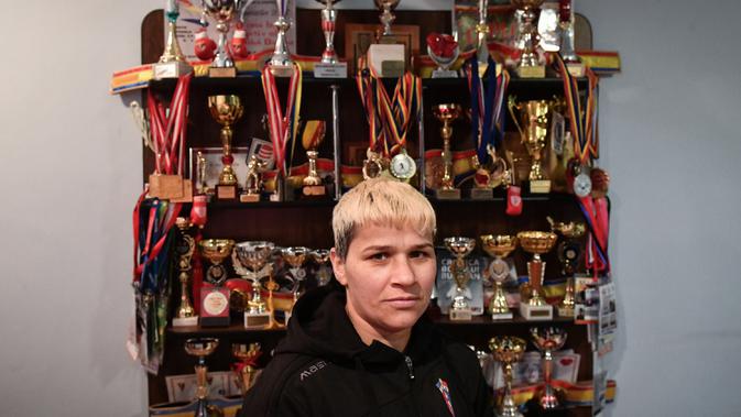 Steluta Duta berpose di depan piala di rumahnya di Buzau City (17/1/2020). Steluta Duta berhasil mengatasi tantangan berat dalam membangun karier sebagai petinju profesional yang sukses di Rumania. (AFP/Daniel Mihailescu)