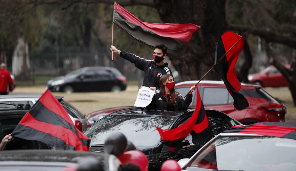 Suporter Newell's Old Boys mengibarkan bendera saat melakukan aksi turun ke jalan di Rosario, Argentina, Kamis (27/8/2020). Dalam aksi tersebut mereka meminta klub memboyong kembali Lionel Messi. (AP Photo/Natacha Pisarenko)