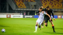 Pemain Latvia Alvis Jaunzems (kiri) berebut bola dengan pemain Belanda Guus Til pada pertandingan sepak bola kualifikasi Grup G Piala Dunia 2022 di Stadion Daugava, Riga, Latvia, 8 Oktober 2021. Belanda menang 1-0. (Gint Ivuskans/AFP)