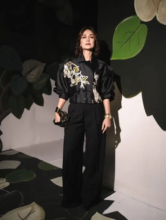 Luna Maya tampil edgy dengan outfit serba hitam. Ia kenakan cropped jacket bermotif bunga yang dibordir dengan trouser pants dan hand bag hitam [@biyanofficial]
