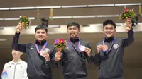 Atlet menembak, Muhammad Sejahtera Dwi Putra (tengah) sosok yang menyumbangkan medali emas pertama buat Tim Indonesia di Asian Games 2022 Hangzhou, China. (NOC Indonesia)