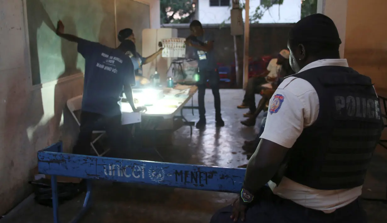 Seorang petugas polisi berjaga saat pemilihan umum yang berlangsung di Port-au-Prince, Haiti (20/11). Pemilu ini tertunda akibat bencana alam dan ketidakstabilan politik yang terjadi di Haiti. (Reuters/Jeanty Junior Augustin)