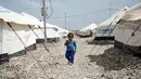 Seorang bocah melintas di antara tenda di kamp penampungan di Hammam al-Alil, Irak, Rabu (3/5). Pengungsi di kamp ini adalah warga Irak yang menyelamatkan diri dari ISIS di Mosul Barat. (AFP PHOTO / FADEL SENNA)