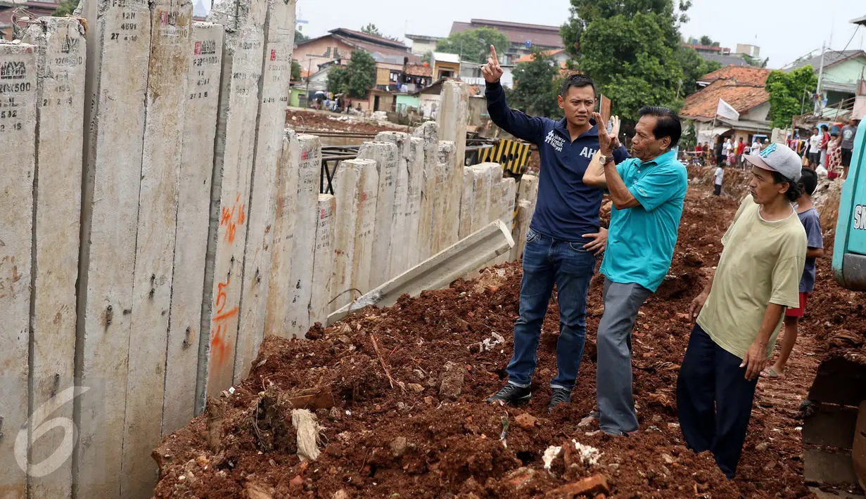 Bakal Cagub DKI, Agus Harimurti Yudhoyono mendengarkan penjelasan warga saat menyusuri pinggiran Sungai Ciliwung yang merupakan lokasi proyek normalisasi, di kawasan Bukit Duri, Jakarta, Kamis (20/10). (Liputan6.com/Gempur M Surya)