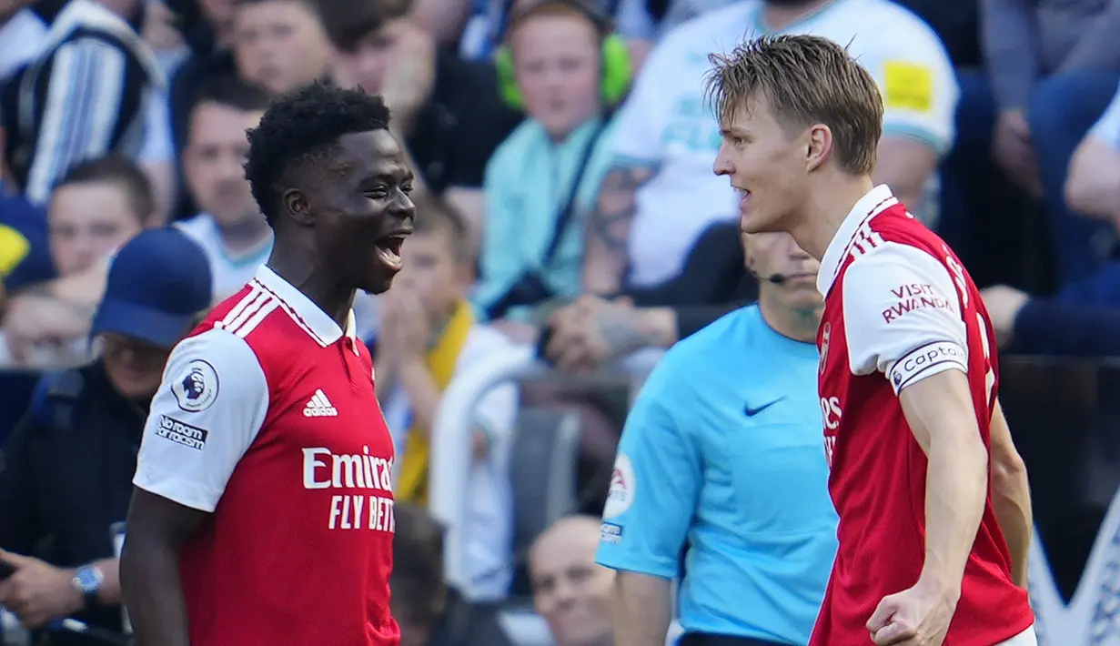 Gelandang Arsenal, Martin Odegaard (kanan) berselebrasi dengan rekannya Bukayo Saka setelah mencetak gol ke gawang Newcastle United pada pertandingan lanjutan Liga Inggris di di stadion St James 'Park di Newcastle, Minggu, 7 Mei 2023. (AP Photo/Jon Super)
