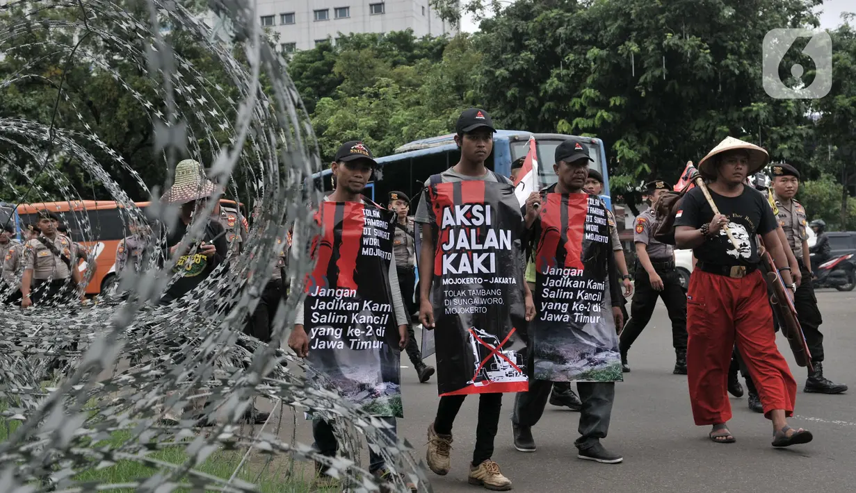 Tiga warga Mojokerto, Ahmad Yani (45), Sugiantoro (31), dan Heru Prasetiyo (24) bersama aktivis saat tiba di seberang Istana Negara, Jakarta, Kamis (6/2/2020). Mereka berjalan kaki dari Mojokerto meminta pemerintah menghentikan aktivitas penambangan di Sungai Woro. (merdeka.com/Iqbal S Nugroho)