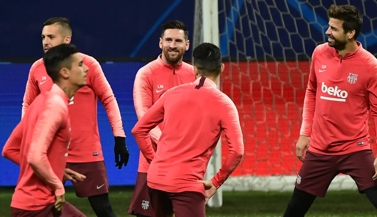 Pemain Barcelona, Lionel Messi (tengah) bercanda dengan rekan setimnya, Jordi Alba dan Gerard Pique selama sesi latihan menjelang laga lanjutan Grup B Liga Champions menghadapi Inter Milan di stadion San Siro, Senin (5/11). (Miguel MEDINA/AFP)