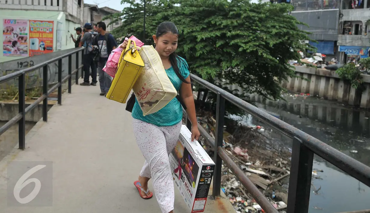 Seorang warga sambil membawa barang miliknya mulai meninggalkan kawasan Kalijodo, Jakarta, Kamis (18/2). Lokalisasi itu mulai ditinggalkan penghuni sejak berkembangnya wacana penggusuran kawasan Kalijodo. (Liputan6.com/Gempur M Surya)