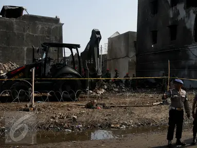 Petugas berdiri di dekat kawat berduri yang mengelilingi lokasi jatuhnya pesawat Hercules C-130, di Jalan Jamin Ginting, Medan, Sumut, Kamis (2/7/2015). Untuk mensterilisasi lokasi, petugas memasang barikade kawat berduri. (Liputan6.com/Johan Tallo)