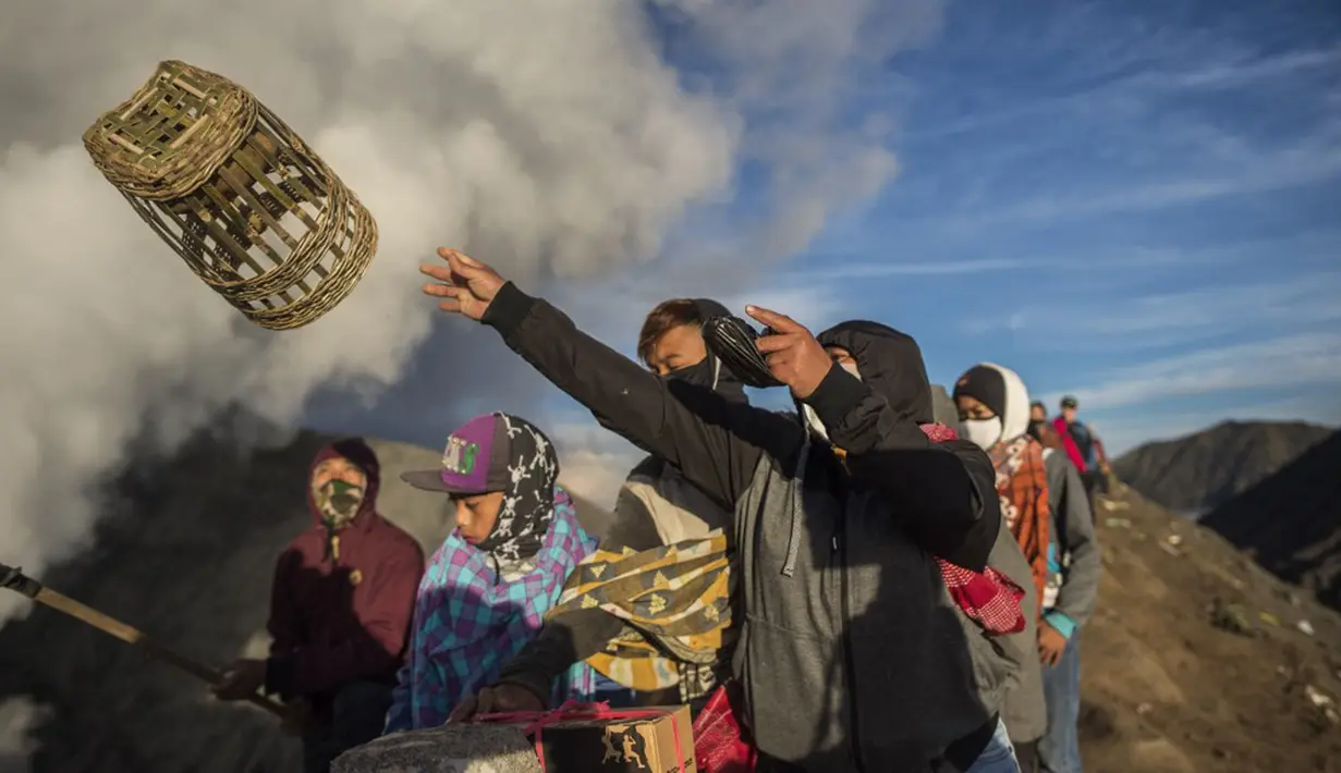 Suku Tengger melarung sesajen ke kawah Gunung Bromo saat upacara Yadnya Kasada di Probolinggo, Jawa Timur, Sabtu (26/6/2021). Suku Tengger mempersembahkan sesajen berupa beras, buah, ternak, dan barang lainnya untuk mencari berkah dari dewa. (Juni Kriswanto/AFP)