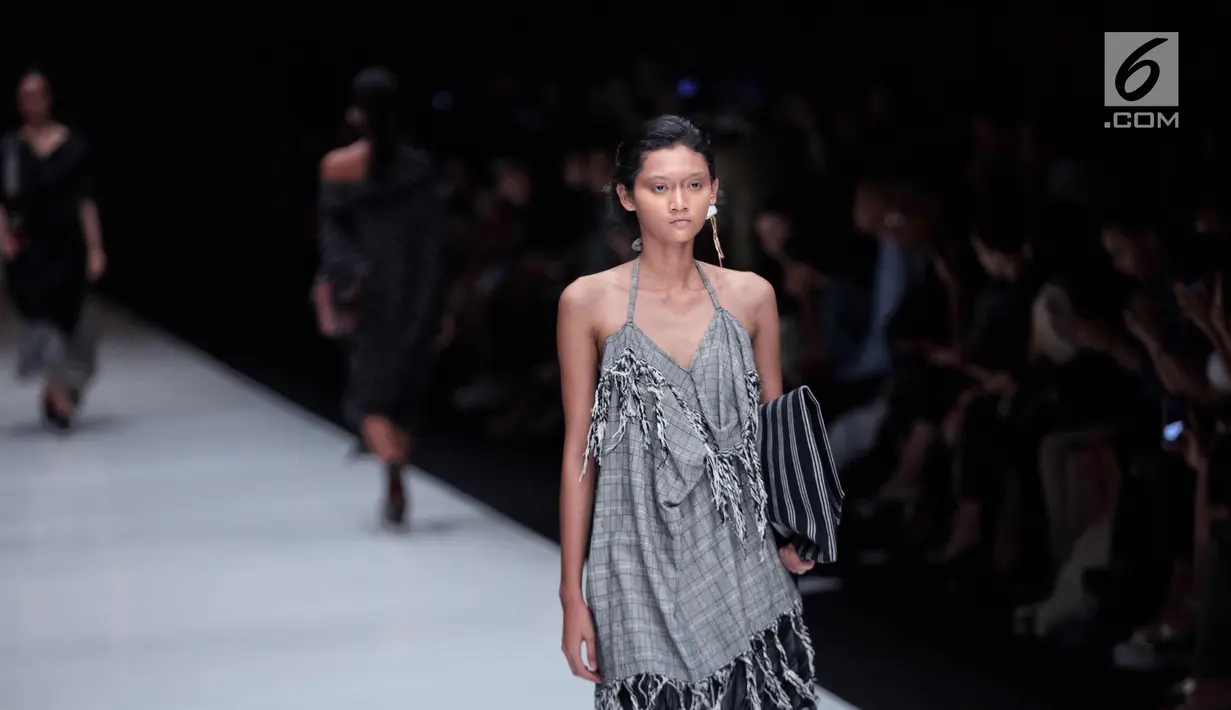 Seorang model berjalan diatas catwalk membawakan rancangan karya Lulu Lutfi Labibi dalam Jakarta Fashion Week 2018 di Senayan City, Jakarta, Kamis (26/10). Pada JFW 2018 Lulu menghadirkan koleksi bertema 'Persimpangan'. (Liputan6.com/Faizal Fanani)