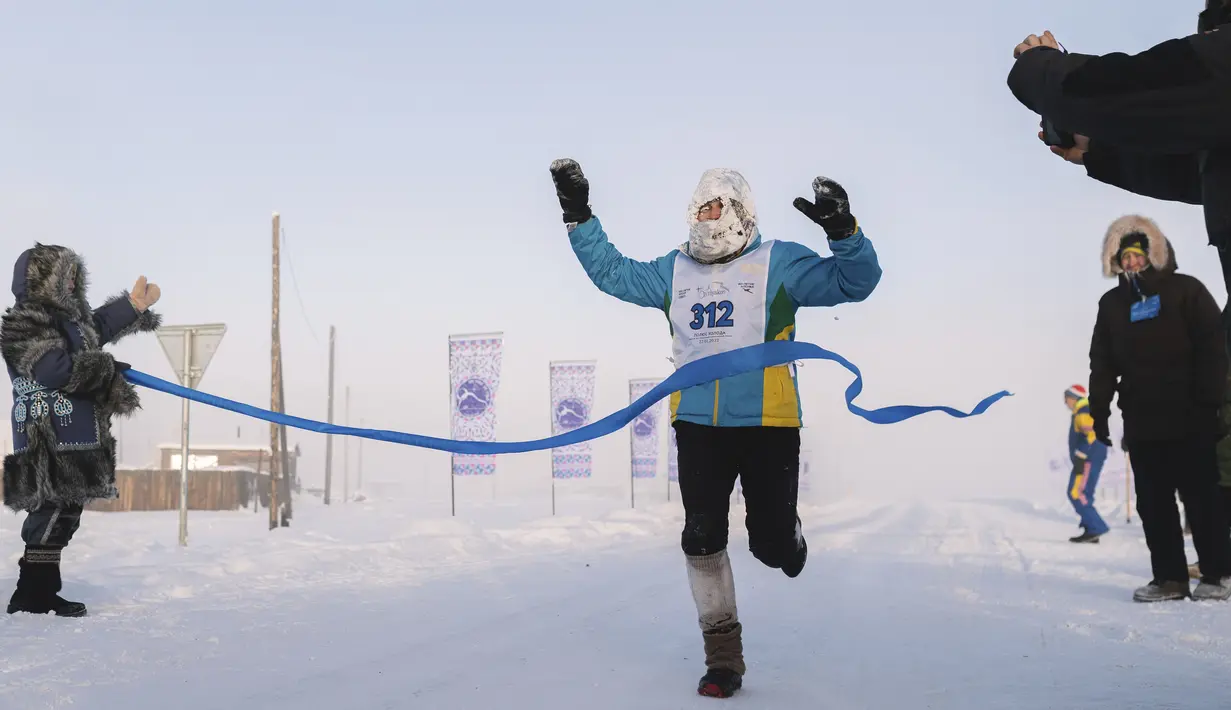 Seorang pelari mencapai garis finish maraton terdingin di Dunia Internasional pada suhu minus 53 derajat (-63,4 Fahrenheit) di dekat Oymyakon, republik Sakha, juga dikenal sebagai Yakutia, Rusia, 22 Januari 2022. Sebanyak 65 pelari bersaing dalam suhu yang sangat rendah (AP Photo/Ivan Nikiforov)