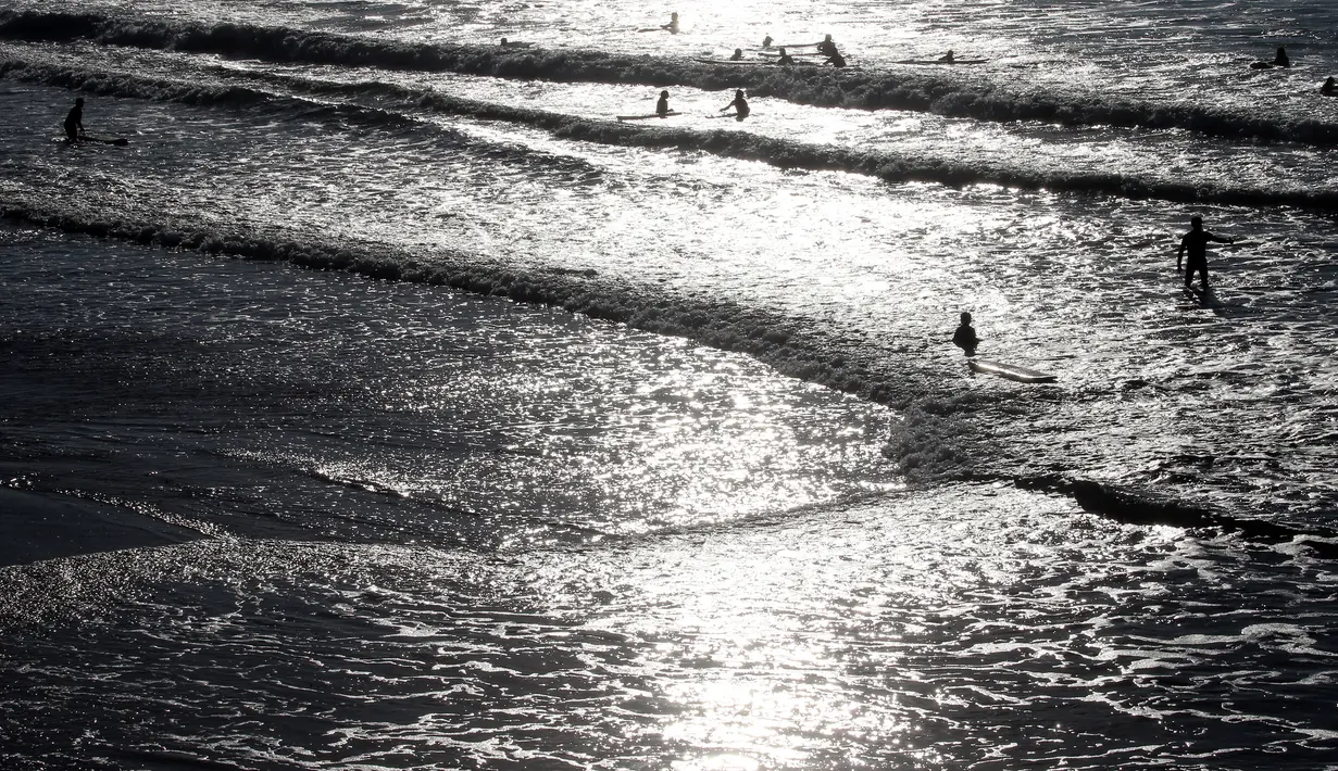 Orang-orang berenang di Samudra Atlantik di Biarritz, Prancis barat daya, Rabu (27/10/2021). Suhu di Prancis barat daya mencapai 20 derajat Celcius (68 Fahrenheit). (AP Photo/Bob Edme)