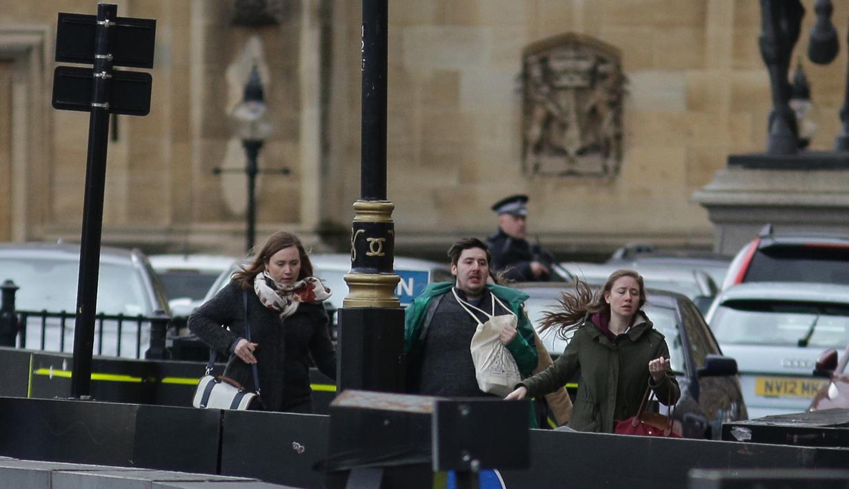 Sejumlah orang berlarian menjauh dari gedung Parlemen Inggris di London, Rabu (22/3). Kepanikan melanda ketika rangkaian serangan yang menewaskan setidaknya lima orang terjadi hanya beberapa meter dari pusat Gedung Parlemen. (DANIEL LEAL-OLIVAS / AFP)