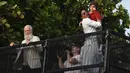 Aktor Bollywood, Shah Rukh Khan menggendong putranya, Abram Khan menyapa para fans yang berkumpul di depan rumahnya pada perayaan Idul Fitri di Mumbai, Rabu (5/6/2019). Ribuan penggemar kerap berkumpul di depan rumah Shah Rukh Khan di momen-momen tertentu. (SUJIT JAISWAL/AFP)