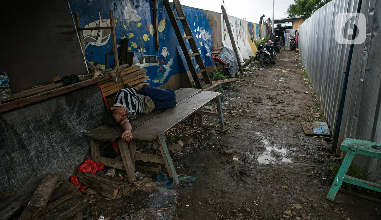 Seorang pria tidur di kawasan Kampung Akuarium, Jakarta, Selasa (17/2/2021). Badan Pusat Statistik (BPS) mengungkapkan jumlah penduduk miskin Indonesia pada September 2020 mencapai 27,55 juta orang, meningkat 2,76 juta dibandingkan posisi September 2019. (Liputan6.com/Faizal Fanani)
