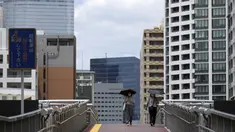 Dua wanita yang mengenakan masker untuk mencegah penyebaran virus corona berjalan di dekat desa atlet untuk digunakan selama Olimpiade dan Paralimpiade Tokyo 2020 di Tokyo, Senin (31/5/2021). Jepang mengkonfirmasi lebih dari 260 kasus virus corona baru pada hari Senin. (AP Photo/Eugene Hoshiko)