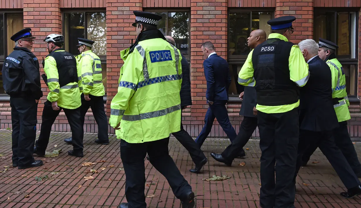 Pemain Everton, Wayne Rooney (tengah) dikawal Polisi saat memenuhi panggilan pengadilan Stockport Magistrates di Stockport, Inggris, (18/9/2017). Kehadiran Rooney di pengadilan karena kedapatan mengemudi saat mabuk. (AFP/ Paul Ellis)
