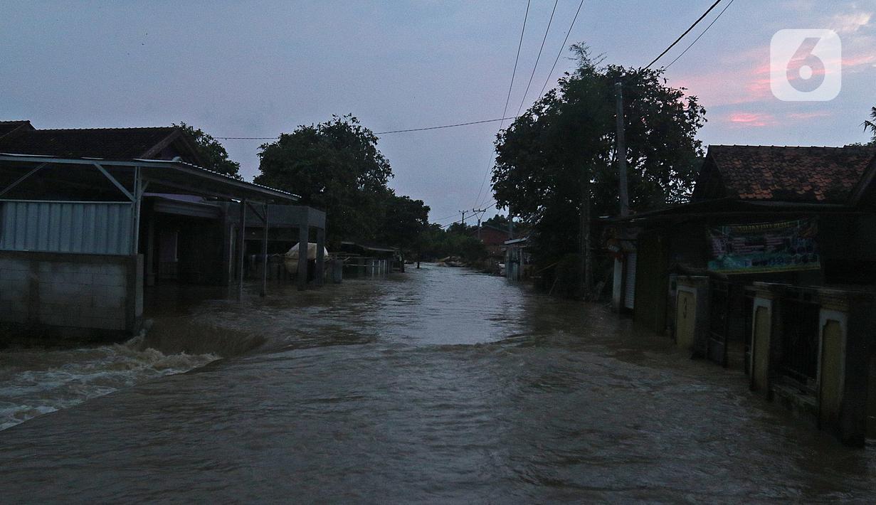 Suasana banjir akibat tanggul jebol di Desa Sumberurip Pebayuran, Kabupaten Bekasi, Jawa Barat, Senin (22/2/2021). Banjir akibat luapan sungai Citarum mengakibatkan 5 Desa terisolir selama tiga hari akibat tanggul sungai Citarum jebol. (Liputan6.com/Herman Zakharia)