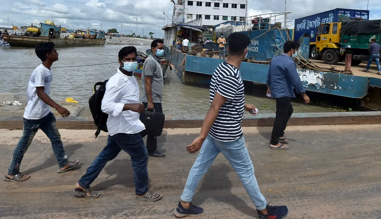 Orang-orang berjalan untuk naik feri menuju kota asal mereka setelah pelonggaran lockdown nasional COVID-19 di Sreenagar, Selasa (13/7/2021). Pemerintah Bangladesh melonggarkan lockdown yang sedang berlangsung selama seminggu mulai 15 hingga 22 Juli untuk perayaan Idul Adha. (Munir Uz zaman/AFP)
