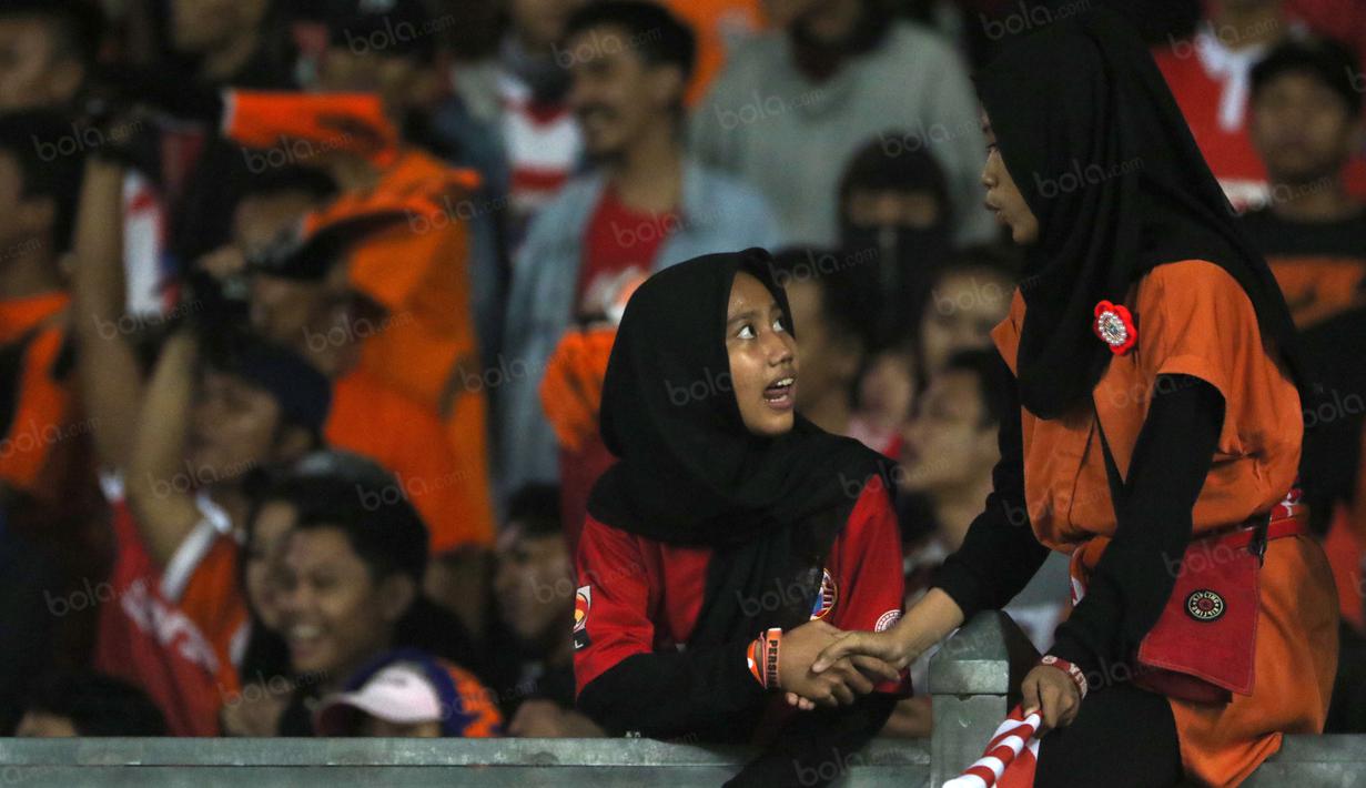 Dua suporter Persija Jakarta berkenalan saat mendukung timnya melawan Sriwijaya FC di Stadion Utama Gelora Bung Karno pada laga Torabika SC 2016, (24/6/2016).  (Bola.com/Nicklas Hanoatubun)