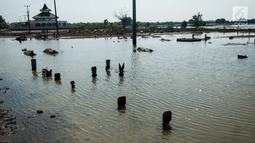 Banjir akibat pasang air laut di Desa Pantai Bahagia mengakibatkan pemakaman dan sekolah terendam serta akses jalan terputus, Jawa Barat, Jumat (9/6).(Liputan6.com/Gempur M Surya)