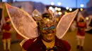 Seorang wanita mengenakan topeng dan kostum peri menari saat mengikuti parade tahunan di La Paz, Bolivia (24/11). Parade menyambut datangnya Natal ini selalu digelar setiap tahunnya. (AP Photo/Juan Karita)