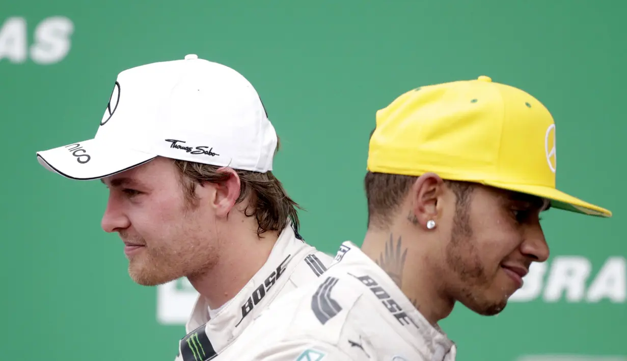 Ekspresi dua pebalap Mercedes GP, Nico Rosberg (kiri) dan Lewis Hamilton, di podium juara F1 GP Brasil di Sirkuit Interlagos, Sao Paulo, Brasil, Senin (16/11/2015) dini hari WIB. (EPA/Fernando Bizerra Jr)