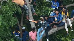 Ekspresi suporter Sri Lanka saat menyaksikan pertandingan kriket antara Sri Lanka dan India  pada One Day International (ODI) di Stadion Kriket Internasional Rangiri Dambulla di Dambulla (20/8). (AFP Photo/Lakruwan Wanniarachchi)