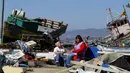 Warga duduk di samping puing-puing dari toko mereka usai gempa bumi melanda Kota Coquimbo, Chile (17/9/2015). Gempa yang menewaskan sekitar sepuluh orang dan memaksa satu juta orang mengungsi dari rumah mereka ke dekat pantai. (REUTERS/Ivan Alvarado)