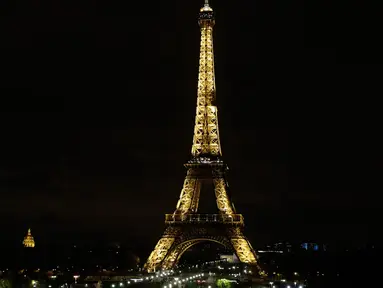 Lampu Menara Eiffel di Paris dipadamkan sebagai penghormatan kepada korban serangan teroris di Masjid Bir el-Abd, Semenanjung Sinai, Mesir (24/11). Menurut saksi, para pelaku menggunakan empat mobil off road. (AFP Photo/Thomas Samson)