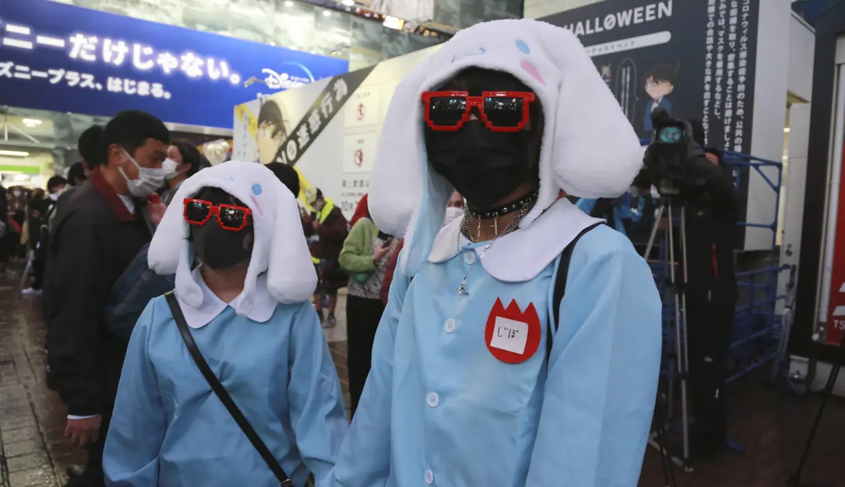 Orang-orang yang mengenakan kostum Halloween berkumpul di distrik Shibuya yang popular di Tokyo, Minggu (31/10/2021). Sebanyak 500 polisi anti huru-hara Kepolisian Metropolitan Tokyo dikerahkan untuk mengamankan perayaan malam Halloween sejak 30 hingga 31 Oktober. (AP Photo/Koji Sasahara)