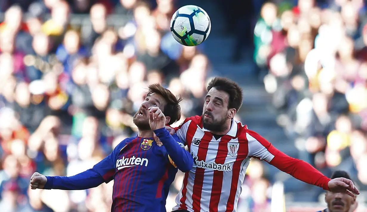 Striker Barcelona Lionel Messi berebut bola di udara dengan pemain Athletic Bilbao Benat Etxebarria saat pertandingan La Liga Spanyol di stadion Camp Nou di Barcelona (18/3). Messi berhasil menyumbang satu gol untuk Barcelona. (AP Photo/Manu Fernandez)