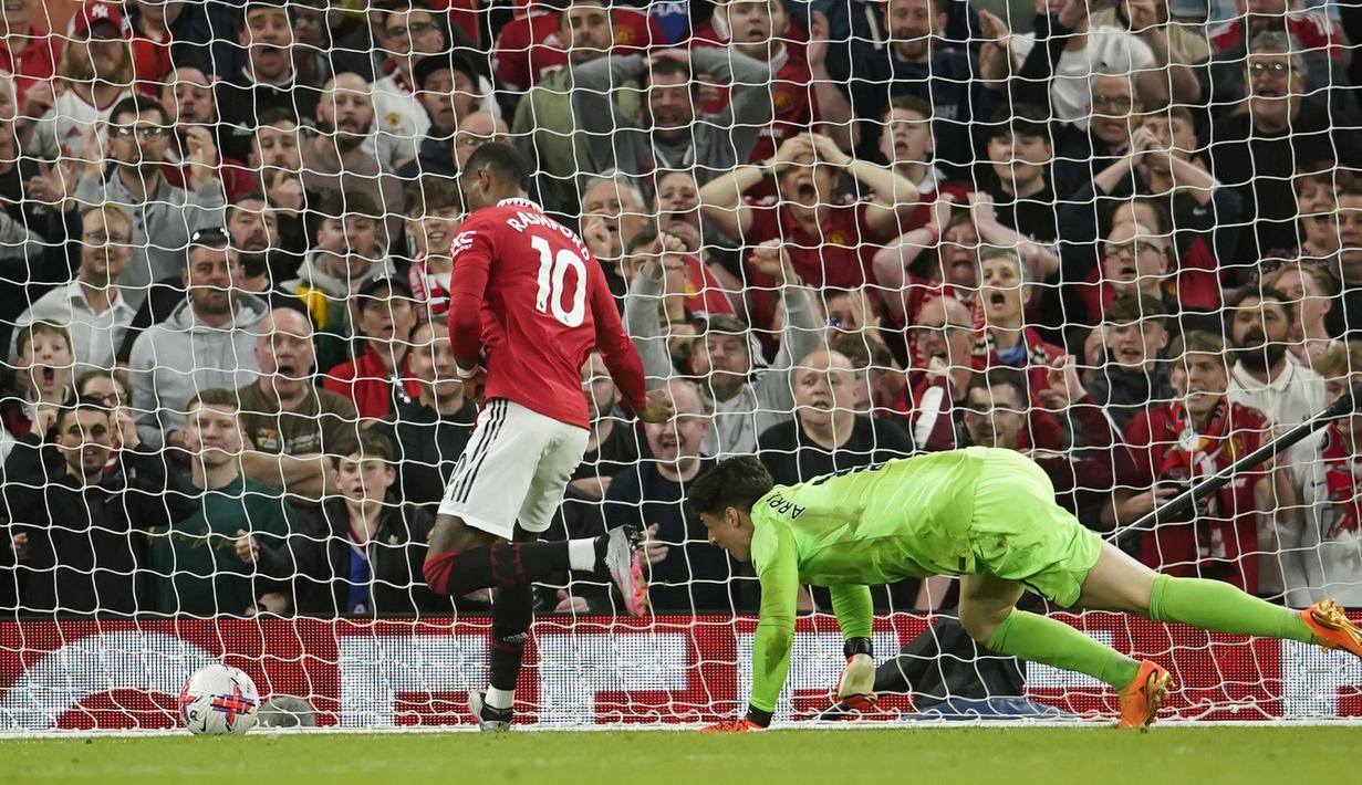 Pemain MU, Marcus Rashford (kiri), berhasil mengelabui penjaga gawang Chelsea, Kepa Arrizabalaga, dalam pertandingan partai tunda pekan ke-32 English Premier League 2022/2023 yang berlangsung di Old Trafford, Jumat (26/5/2023) dini hari WIB. (AP Photo/Dave Thompson)