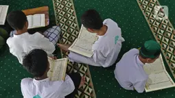 Sejumlah santri membaca Al-Quran di Pesantren Nuu Waar Al Fatih Kaffah Nusantara (AFKN) di Setu, Kabupaten Bekasi, Jawa Barat, Sabtu (1/5/2021). Kegiatan Khatam Al-Quran tersebut dilakukan rutin setiap bulan Ramadhan oleh 750 santri dan santriwati. (Liputan6.com/Herman Zakharia)