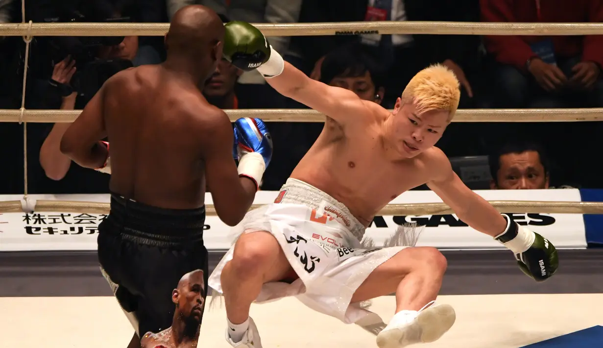 Petinju, Floyd Mayweather, menjatuhkan kickboxer, Tenshin Nasukawa, pada laga eksebisi di Saitama Super Arena, Saitama, Senin (31/1). Tanding dengan aturan tinju, Mayweather menang TKO di ronde pertama. (AFP/Toshifumi Kitamura)