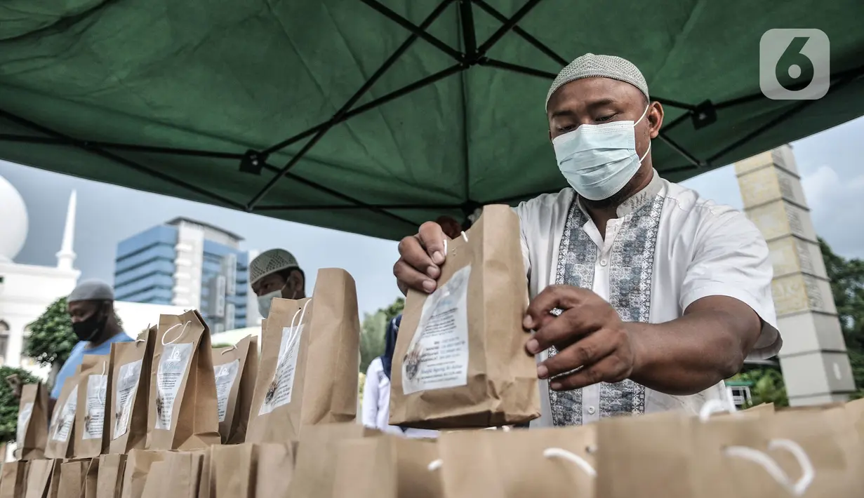 Petugas menyiapkan takjil untuk dibagikan kepada pengendara secara drive thru di Kompleks Masjid Al-Azhar, Jakarta, Selasa (13/4/2021). Pengelola Masjid Al-Azhar menyiapkan 500 bungkus takjil per hari yang dibagikan secara drive thru guna mencegah penyebaran COVID-19. (merdeka.com/Iqbal S. Nugroho)
