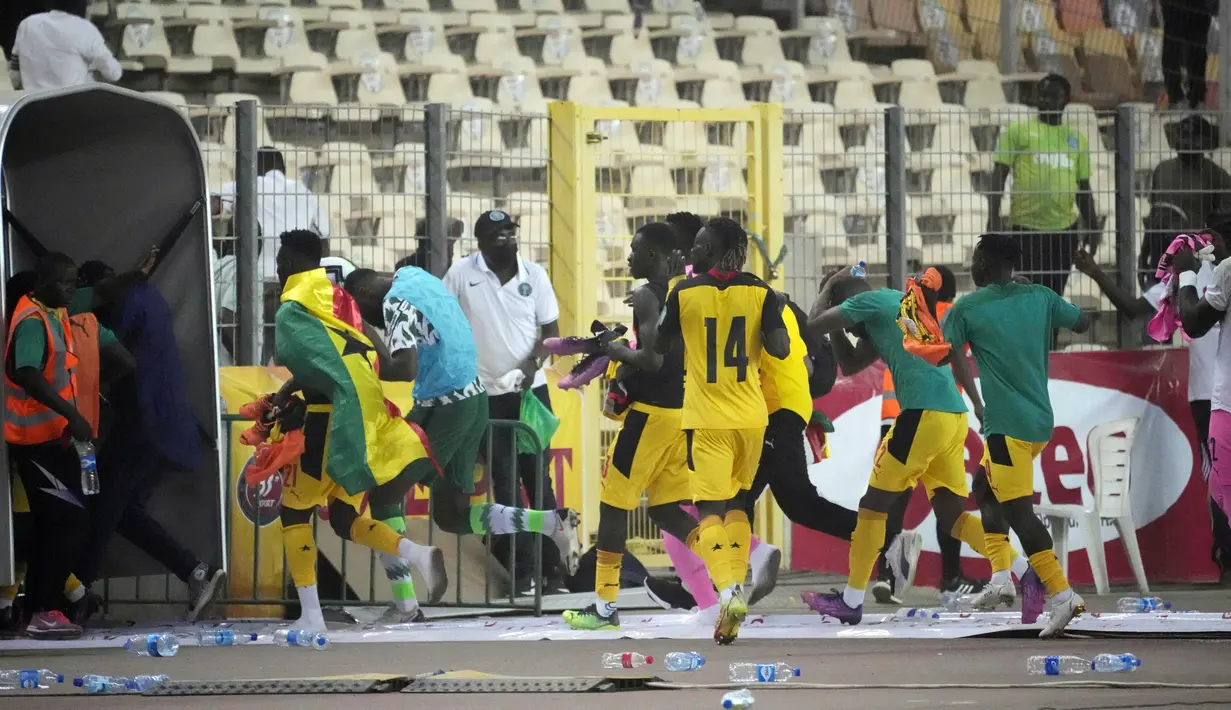 Pemain Ghana berlari keluar lapangan setelah diserbu pada akhir pertandingan kualifikasi Piala Dunia 2022 melawan Nigeria di Stadion Moshood Abiola, Abuja, Nigeria, 29 Maret 2022. Fans Nigeria ngamuk setelah gagal lolos ke Piala Dunia 2022. (AP Photo/Sunday Alamba)