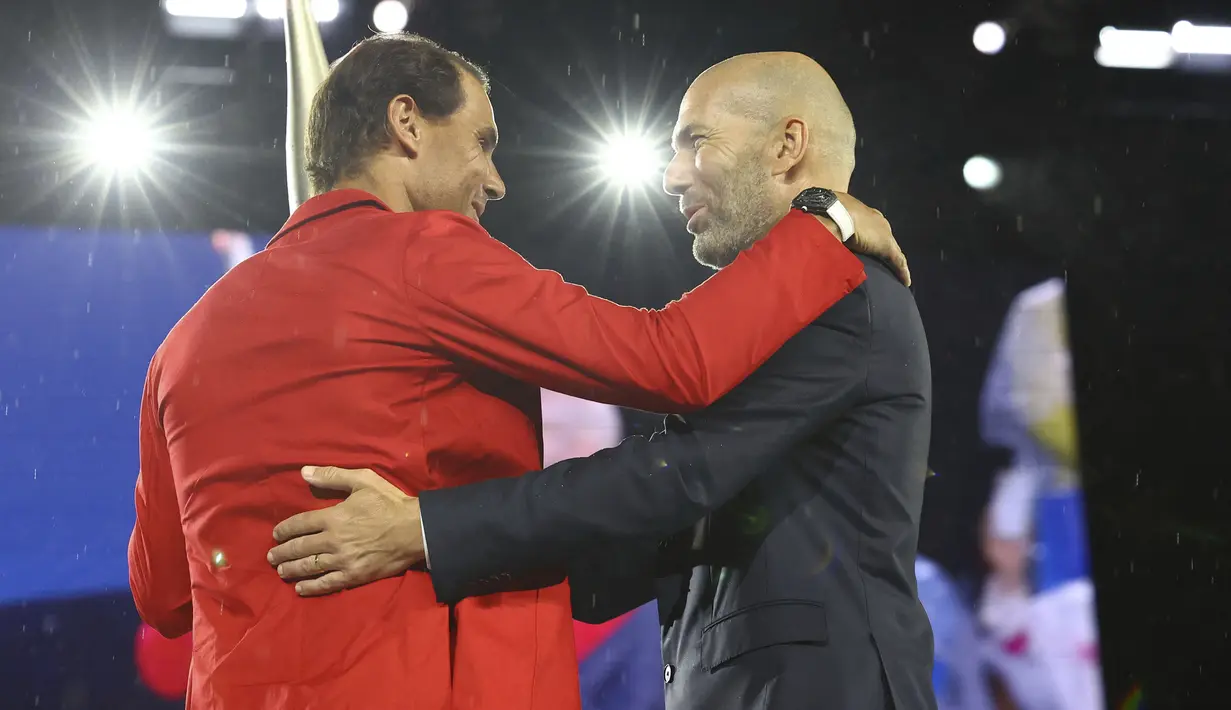 Petenis asal Spanyol, Rafael Nadal, berpelukan setelah menerima obor dari legenda sepak bola Prancis, Zinedine Zidane, dalam acara pembukaan Olimpiade Paris 2024 di Sungai Seine, Prancis. (Stephanie Lecocq/Pool Photo via AP)