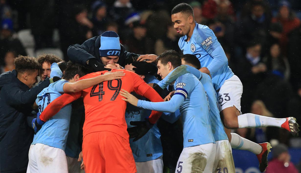 Para pemain Manchester City merayakan kemenangan atas Leicester pada laga Piala Liga di Stadion King Power, Leicester, Selasa (18/12). Leicester kalah adu penalti dari City. (AFP/Lindsey Parnaby)