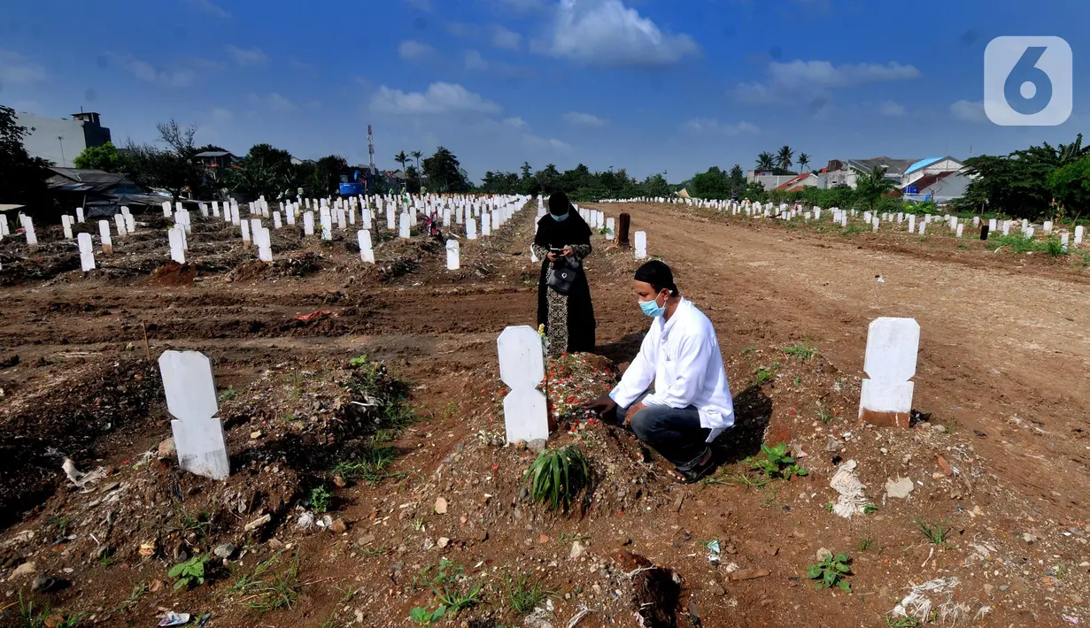 Warga melakukan ziarah makam menyambut bulan Ramadhan 1442 H di Tempat Pemakaman Umum (TPU) khusus covid-19 di Srengseng sawah 2, Jakarta Selatan, Jumat (09/04/2021). Tradisi ziarah makam dalam menyambut bulan Ramadhan setiap tahun dilakukan oleh umat Islam.
(merdeka.com/Arie Basuki)