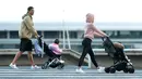 Cristiano Ronaldo bersama kekasihnya Georgina Rodriguez mengajak anak-anaknya berjalan santai di Funchal, Portugal, Sabtu (28/3/2020). Bintang Juventus ini memilih pulang kampung saat Serie A dihentikan sementara karena wabah virus corona. (AFP/Helder Santos)